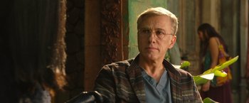 Movie still from “Alita: Battle Angel” (2019), directed by Robert Rodriguez – An older man wearing glasses sitting in a chair; Close Up shot, Low angle