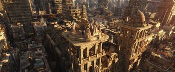 Movie still from “Alita: Battle Angel” (2019), directed by Robert Rodriguez – An aerial view of an old building with many statues on it; Extreme Wide shot, Overhead angle