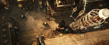 Movie still from “Alita: Battle Angel” (2019), directed by Robert Rodriguez – Looking down at a man standing on a building; Wide shot, Overhead angle