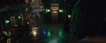 Movie still from “Alita: Battle Angel” (2019), directed by Robert Rodriguez – A man walking down a street at night; Extreme Wide shot, High angle