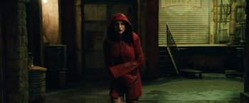 Movie still from “Alita: Battle Angel” (2019), directed by Robert Rodriguez – A woman in a red hooded jacket and fishnet stockings; Medium shot, Low angle