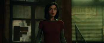 Movie still from “Alita: Battle Angel” (2019), directed by Robert Rodriguez – A woman standing in front of a window in a room; Medium shot, High angle