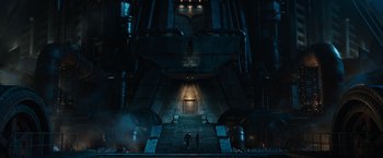 Movie still from “Alita: Battle Angel” (2019), directed by Robert Rodriguez – Two people are standing in front of a building with stairs; Extreme Wide shot, Low angle