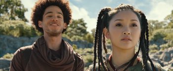 Movie still from “Alita: Battle Angel” (2019), directed by Robert Rodriguez – A man and a woman standing next to each other in front of trees; Close Up shot, Low angle