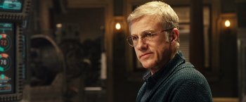 Movie still from “Alita: Battle Angel” (2019), directed by Robert Rodriguez – An older man wearing glasses and a blue sweater; Close Up shot, Low angle