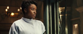 Movie still from “Alita: Battle Angel” (2019), directed by Robert Rodriguez – A woman is looking into the distance with a serious look on her face; Close Up shot, Over the shoulder angle