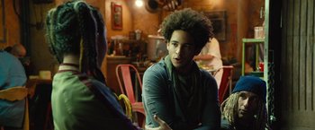 Movie still from “Alita: Battle Angel” (2019), directed by Robert Rodriguez – A man with a curly afro talking to a woman; Close Up shot, Over the shoulder angle