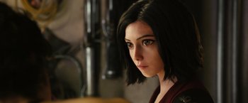 Movie still from “Alita: Battle Angel” (2019), directed by Robert Rodriguez – A person with short black hair; Close Up shot, Over the shoulder angle
