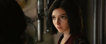 Movie still from “Alita: Battle Angel” (2019), directed by Robert Rodriguez – A person with short black hair; Close Up shot, Over the shoulder angle