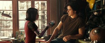 Movie still from “Alita: Battle Angel” (2019), directed by Robert Rodriguez – A young man and a young woman are holding hands; Medium shot, Over the shoulder angle