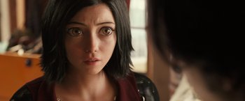 Movie still from “Alita: Battle Angel” (2019), directed by Robert Rodriguez – A person looking at the camera; Close Up shot, Over the shoulder angle
