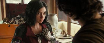 Movie still from “Alita: Battle Angel” (2019), directed by Robert Rodriguez – A person with a robot arm; Close Up shot, Over the shoulder angle