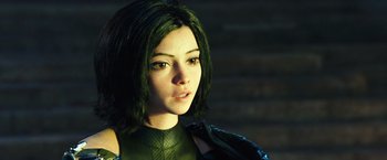 Movie still from “Alita: Battle Angel” (2019), directed by Robert Rodriguez – A person wearing a green outfit; Close Up shot, High angle