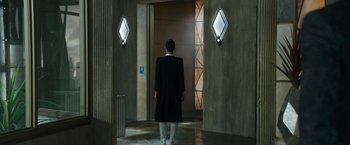 Movie still from “Alita: Battle Angel” (2019), directed by Robert Rodriguez – A man standing in front of an open door; Wide shot, Low angle