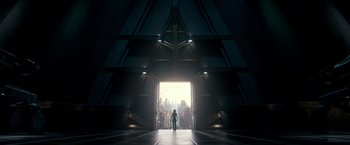 Movie still from “Alita: Battle Angel” (2019), directed by Robert Rodriguez – A person standing in front of an opening in a building; Extreme Wide shot, Low angle