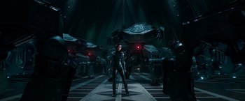 Movie still from “Alita: Battle Angel” (2019), directed by Robert Rodriguez – A woman standing in front of a group of robots; Wide shot, Low angle