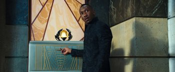 Movie still from “Alita: Battle Angel” (2019), directed by Robert Rodriguez – A man standing in front of a wall holding a stick; Medium shot, Low angle