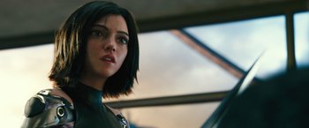 Movie still from “Alita: Battle Angel” (2019), directed by Robert Rodriguez – An image of a woman with a serious look; Close Up shot, Over the shoulder angle
