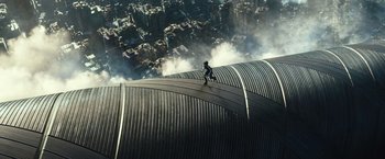 Movie still from “Alita: Battle Angel” (2019), directed by Robert Rodriguez – A man riding a skateboard on top of a metal surface; Extreme Wide shot, Overhead angle