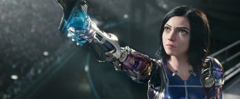 Movie still from “Alita: Battle Angel” (2019), directed by Robert Rodriguez – A woman holding a blue object in her right hand; Close Up shot, Low angle