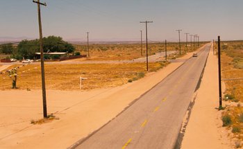 Movie still from “From Dusk Till Dawn” (1996), directed by Robert Rodriguez – An empty road in the middle of a desert area; Extreme Wide shot, High angle