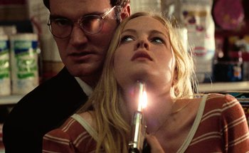 Movie still from “From Dusk Till Dawn” (1996), directed by Robert Rodriguez – A man and a woman looking at a candle; Close Up shot, Low angle