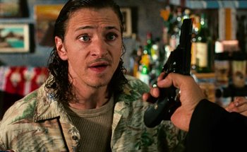 Movie still from “From Dusk Till Dawn” (1996), directed by Robert Rodriguez – A man holding a gun in front of another man's face; Close Up shot, Over the shoulder angle