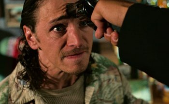 Movie still from “From Dusk Till Dawn” (1996), directed by Robert Rodriguez – A man is looking into a mirror while another man holds a video camera; Close Up shot, Over the shoulder angle