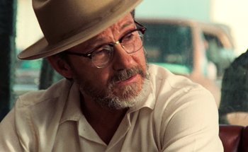 Movie still from “From Dusk Till Dawn” (1996), directed by Robert Rodriguez – An older man wearing a hat and glasses; Close Up shot, Over the shoulder angle