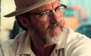 Movie still from “From Dusk Till Dawn” (1996), directed by Robert Rodriguez – An older man wearing glasses and a hat looking to his left; Close Up shot, Low angle
