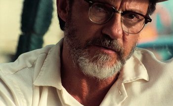 Movie still from “From Dusk Till Dawn” (1996), directed by Robert Rodriguez – An older man wearing glasses and a white shirt; Close Up shot, Over the shoulder angle
