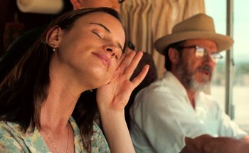 Movie still from “From Dusk Till Dawn” (1996), directed by Robert Rodriguez – A woman with her eyes closed and her hand to her ear; Close Up shot, Over the shoulder angle