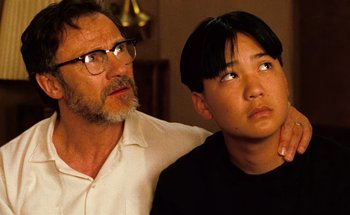 Movie still from “From Dusk Till Dawn” (1996), directed by Robert Rodriguez – A man and a young boy sitting next to each other; Close Up shot, Low angle