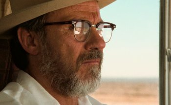 Movie still from “From Dusk Till Dawn” (1996), directed by Robert Rodriguez – An old man with a beard wearing glasses and a hat; Close Up shot, Low angle