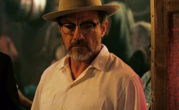 Movie still from “From Dusk Till Dawn” (1996), directed by Robert Rodriguez – An older man wearing glasses and a hat; Close Up shot, Low angle