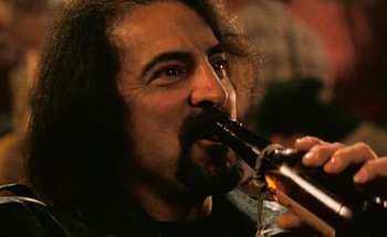 Movie still from “From Dusk Till Dawn” (1996), directed by Robert Rodriguez – A person drinking a beer; Close Up shot, Low angle
