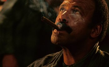 Movie still from “From Dusk Till Dawn” (1996), directed by Robert Rodriguez – A person with a cigar in his mouth; Close Up shot, Low angle