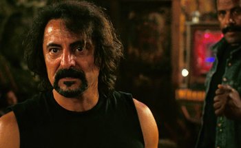 Movie still from “From Dusk Till Dawn” (1996), directed by Robert Rodriguez – A person with long hair and a beard; Close Up shot, Over the shoulder angle