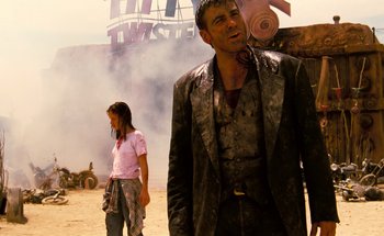 Movie still from “From Dusk Till Dawn” (1996), directed by Robert Rodriguez – A man and a woman standing next to each other in the desert; Medium shot, Low angle