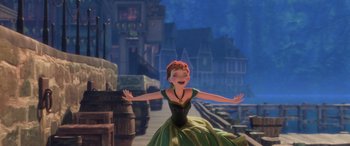 Movie still from “Frozen” (2013), directed by Jennifer Lee – A woman in a green and yellow dress with arms outstreched; Wide shot, Low angle