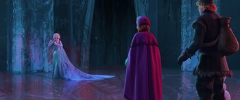 Movie still from “Frozen” (2013), directed by Jennifer Lee – A woman in a purple cape standing in front of a curtain; Wide shot, Over the shoulder angle