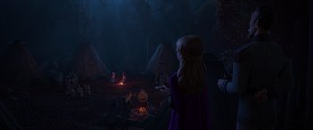 Movie still from “Frozen II” (2019), directed by Jennifer Lee – A group of people sitting around a campfire at night; Wide shot, High angle