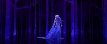 Movie still from “Frozen II” (2019), directed by Jennifer Lee – A woman dressed in a white dress standing next to a forest; Wide shot, Low angle