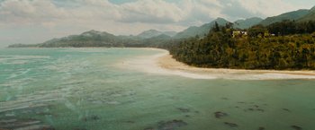 Movie still from “Furious 7” (2015), directed by James Wan – An aerial view of a beach with a body of water in the foreground; Extreme Wide shot, High angle