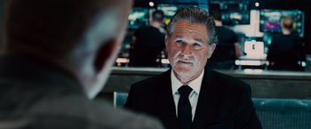 Movie still from “Furious 7” (2015), directed by James Wan – An older man wearing a suit and tie looking at the camera; Close Up shot, Over the shoulder angle