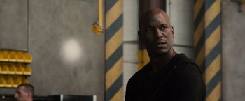 Movie still from “Furious 7” (2015), directed by James Wan – A man with a beard is looking at the camera; Close Up shot, Over the shoulder angle