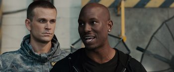 Movie still from “Furious 7” (2015), directed by James Wan – A person with a bald head; Close Up shot, Over the shoulder angle