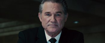 Movie still from “Furious 7” (2015), directed by James Wan – An older man wearing a suit and tie; Close Up shot, Low angle