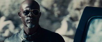 Movie still from “Furious 7” (2015), directed by James Wan – A man with a beard wearing sunglasses and a black shirt; Close Up shot, Low angle