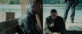 Movie still from “Furious 7” (2015), directed by James Wan – Two men sitting next to each other near a body of water; Medium shot, Over the shoulder angle